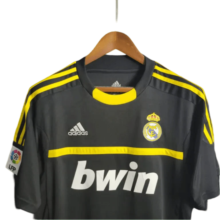 https://cdn.shopify.com/s/files/1/0826/7228/8075/files/20112012-real-madrid-bwin-vintage-goalkeeper-black-retro-kit-838868.webp?v=1741197272