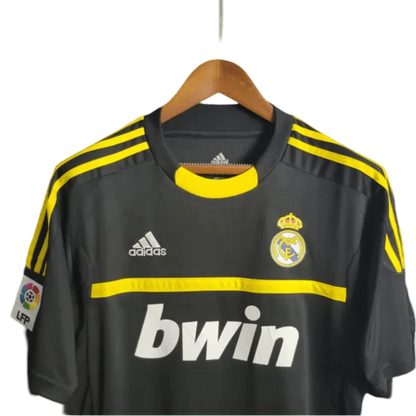 https://cdn.shopify.com/s/files/1/0826/7228/8075/files/20112012-real-madrid-bwin-vintage-goalkeeper-black-retro-kit-838868.webp?v=1741197272