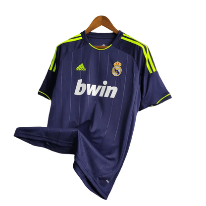https://cdn.shopify.com/s/files/1/0826/7228/8075/files/20122013-real-madrid-bwin-away-retro-kit-107137.webp?v=1741197473