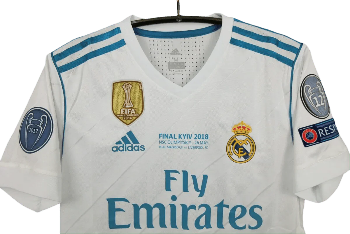 https://cdn.shopify.com/s/files/1/0826/7228/8075/files/20172018-real-madrid-fly-emirates-home-retro-kit-390237.webp?v=1741197468