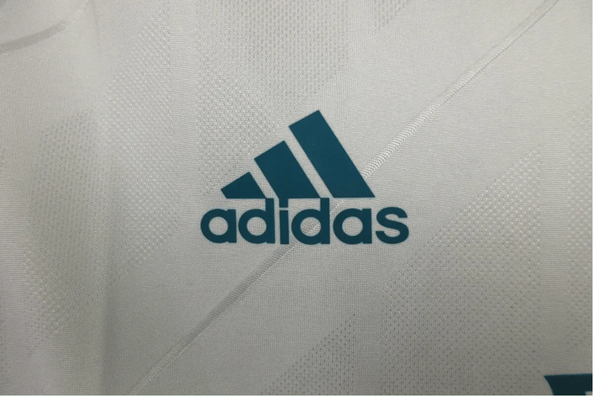 https://cdn.shopify.com/s/files/1/0826/7228/8075/files/20172018-real-madrid-fly-emirates-home-retro-kit-856625.webp?v=1741197466
