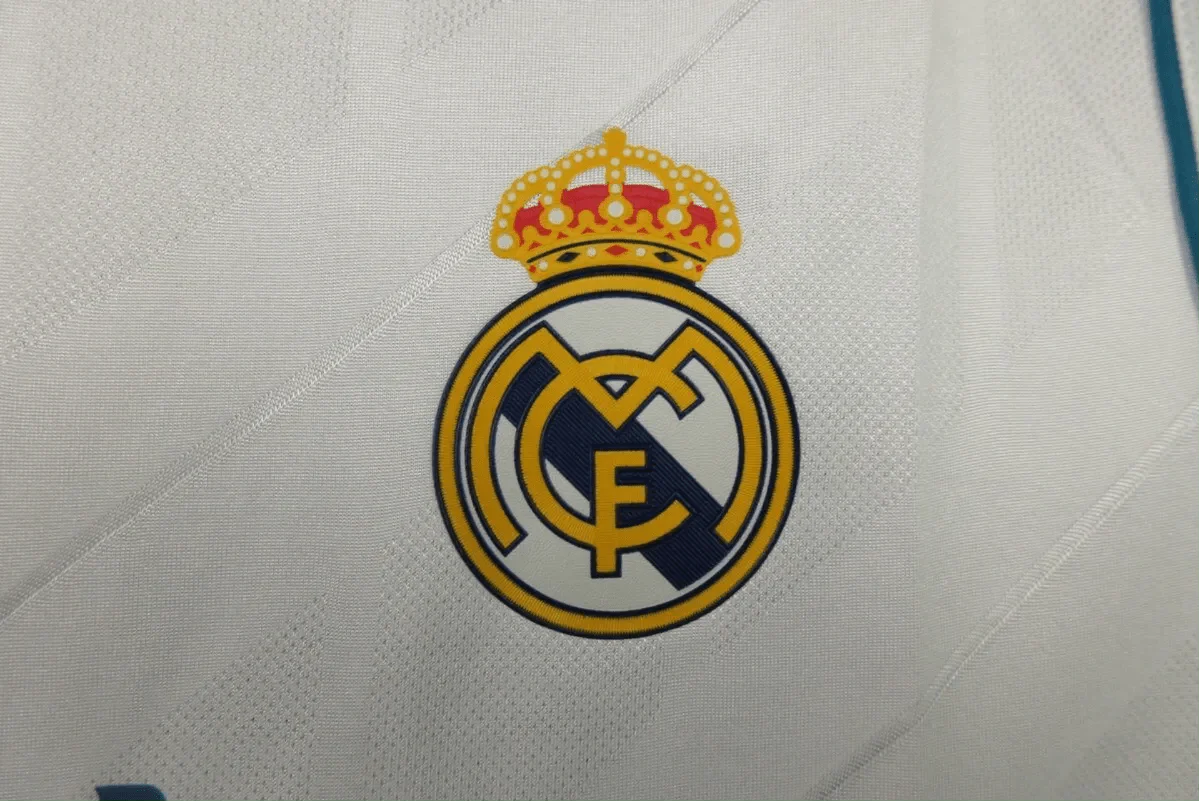 https://cdn.shopify.com/s/files/1/0826/7228/8075/files/20172018-real-madrid-fly-emirates-home-retro-kit-974355.webp?v=1741197466